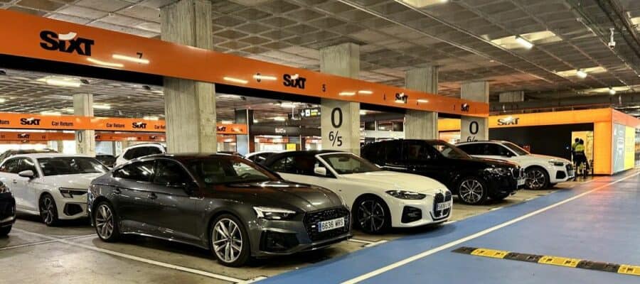 Row of premium rental cars at a Sixt return station, highlighted by a white BMW convertible ready for travelers looking for a stylish drive.