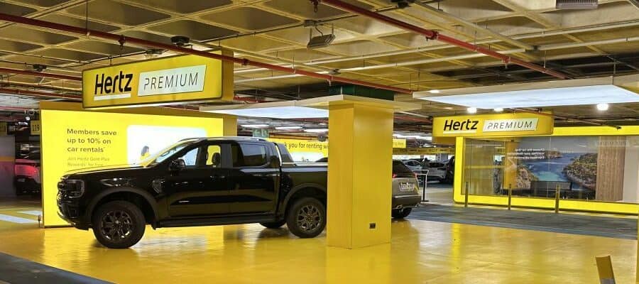 Hertz Premium rental car area with parked vehicles in a brightly lit garage